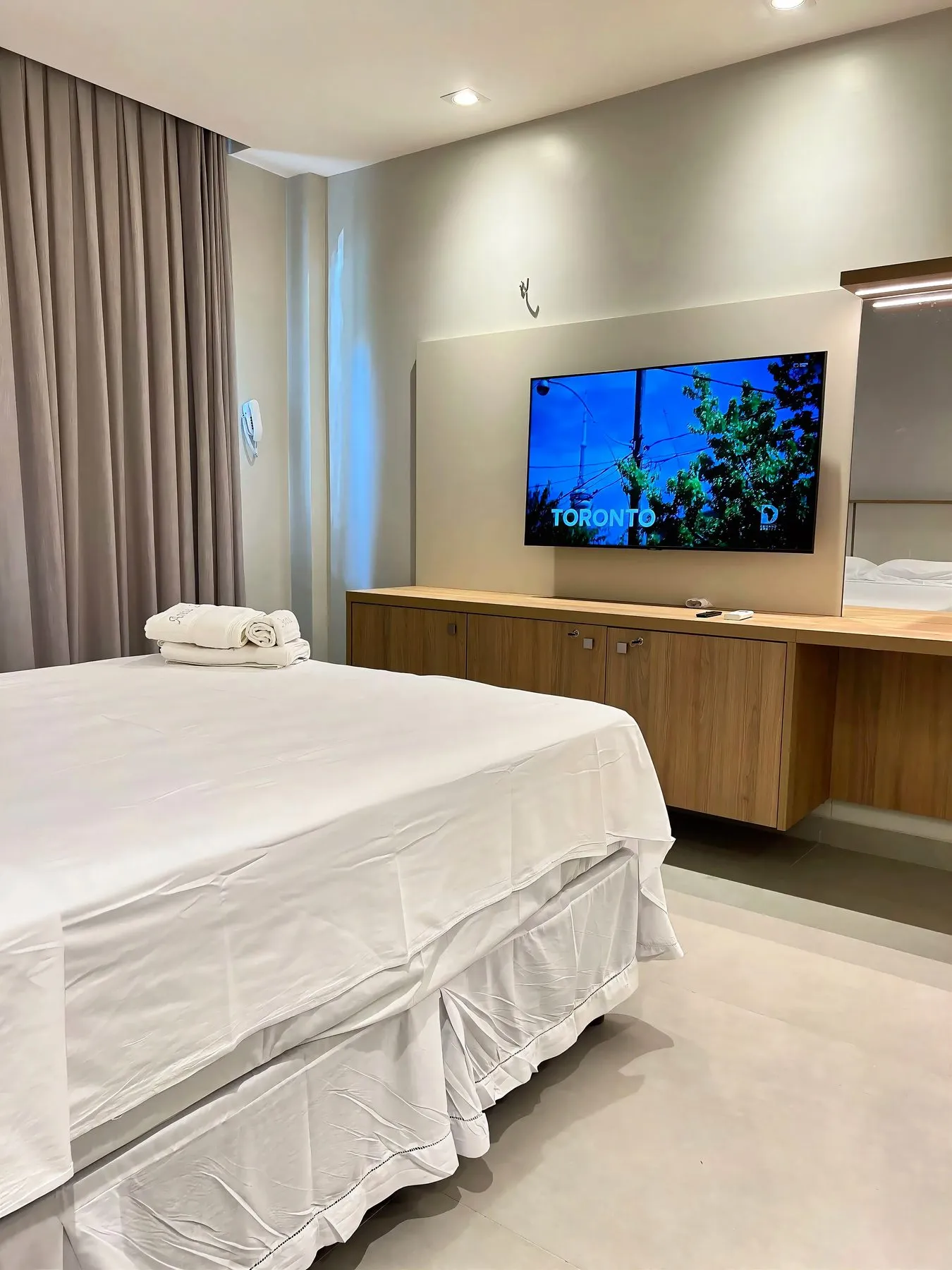 O quarto do apartamento, com TV e bancada